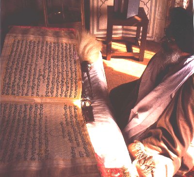 A man reads from the Guru Granth Sahib (source: sikh-history.com)
