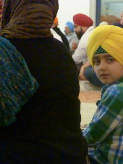 A child takes notice of the camera during the interfaith evening at the Sikh Temple of Utah, March 6 (source: Salt Lake Interfaith Roundtable Facebook page)