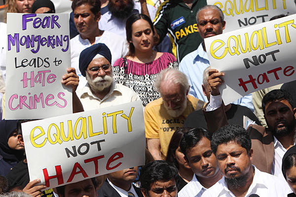 A New York taxi driver who was a victim of a stabbing (bottom right) speaks to the media while surrounded by supporters in August, 2010. (Seth Wenig | AP. Source: Christian Science Monitor)