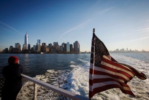 "A woman on the deck of a boat headed to Ellis Island in New York." (Credit: Lucas Jackson/Reuters. Source: New York Times.)